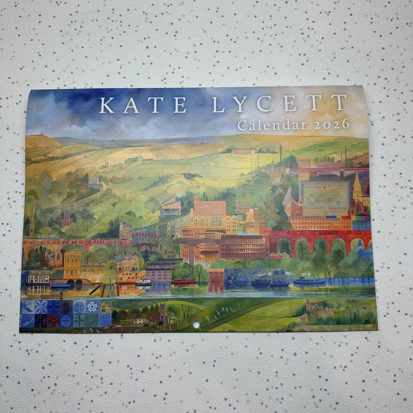 Calendar cover by Kate Lycett with a scenic illustration on a textured white background