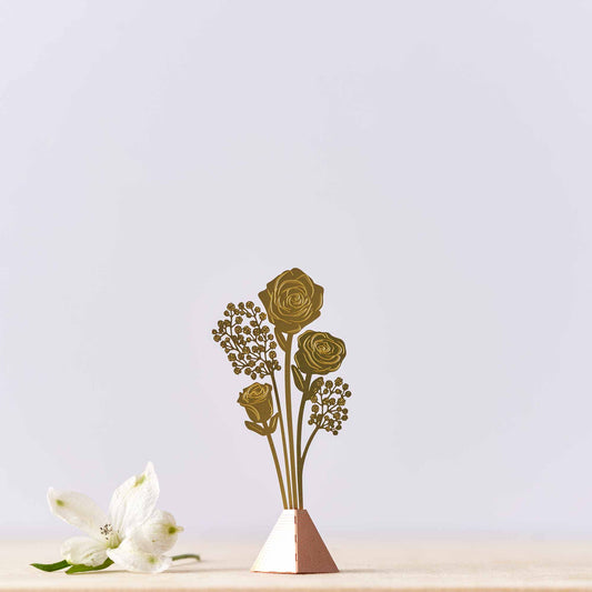 A tiny bouquet of brass roses in a vase n a blue background, with a 'featured in Gift Shop' label at the bottom.