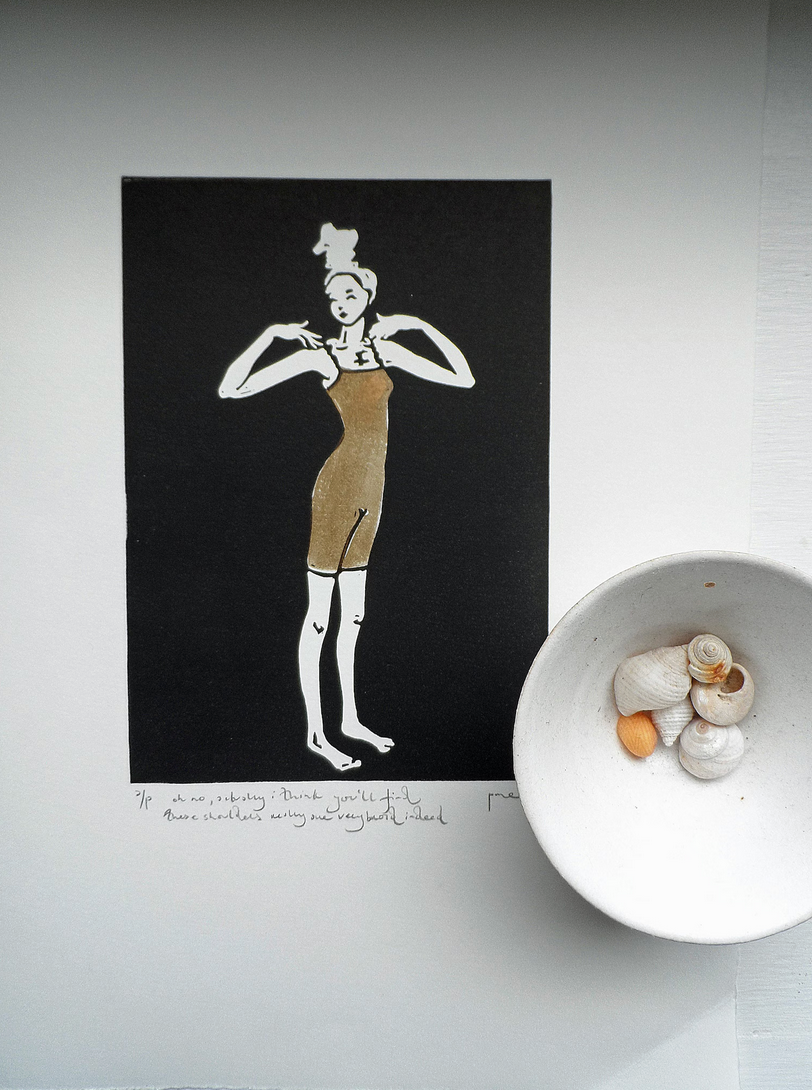 A signed and titled original linocut called Broad Shoulders by Polly Marix-Evans, depicting a figure, displayed on a flat surface with a bowl of shells to the side.