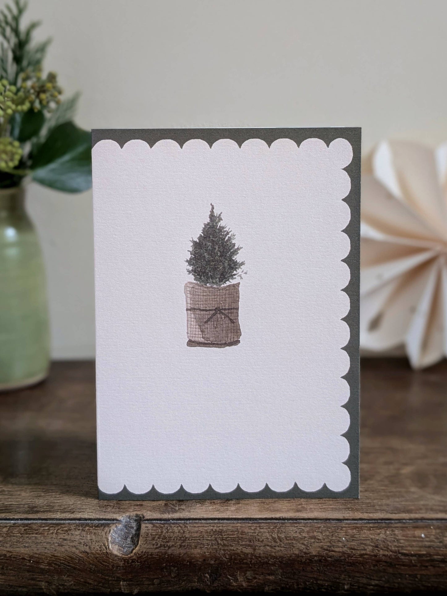 Greeting card with a christmas tree illustration on a wooden surface