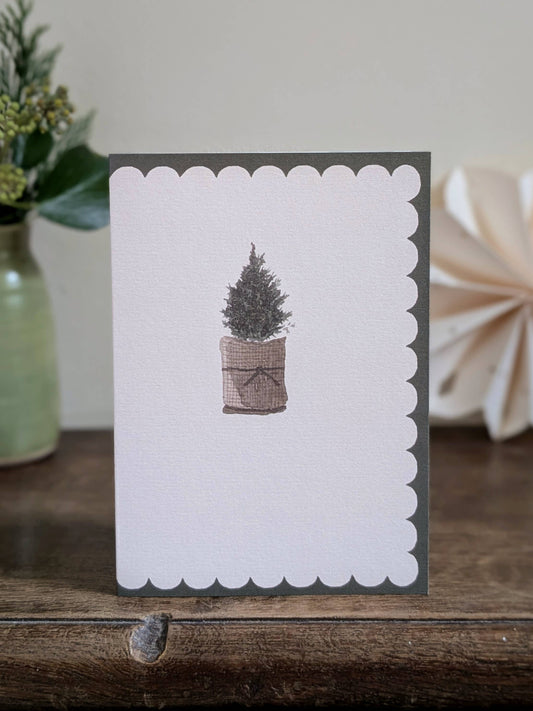 Greeting card with a christmas tree illustration on a wooden surface