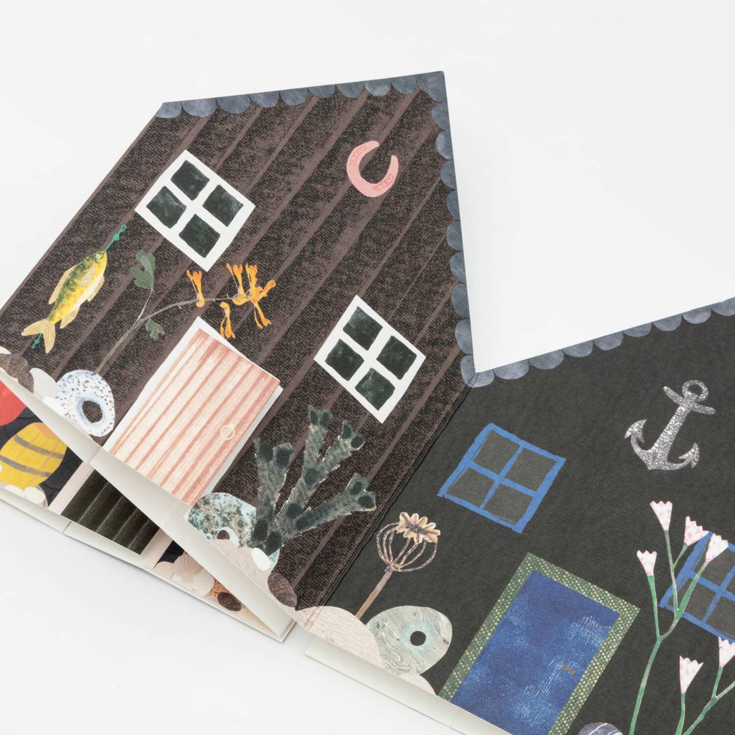 Illustrated fisherman's hut concertina card with various elements like windows, plants, and an anchor.