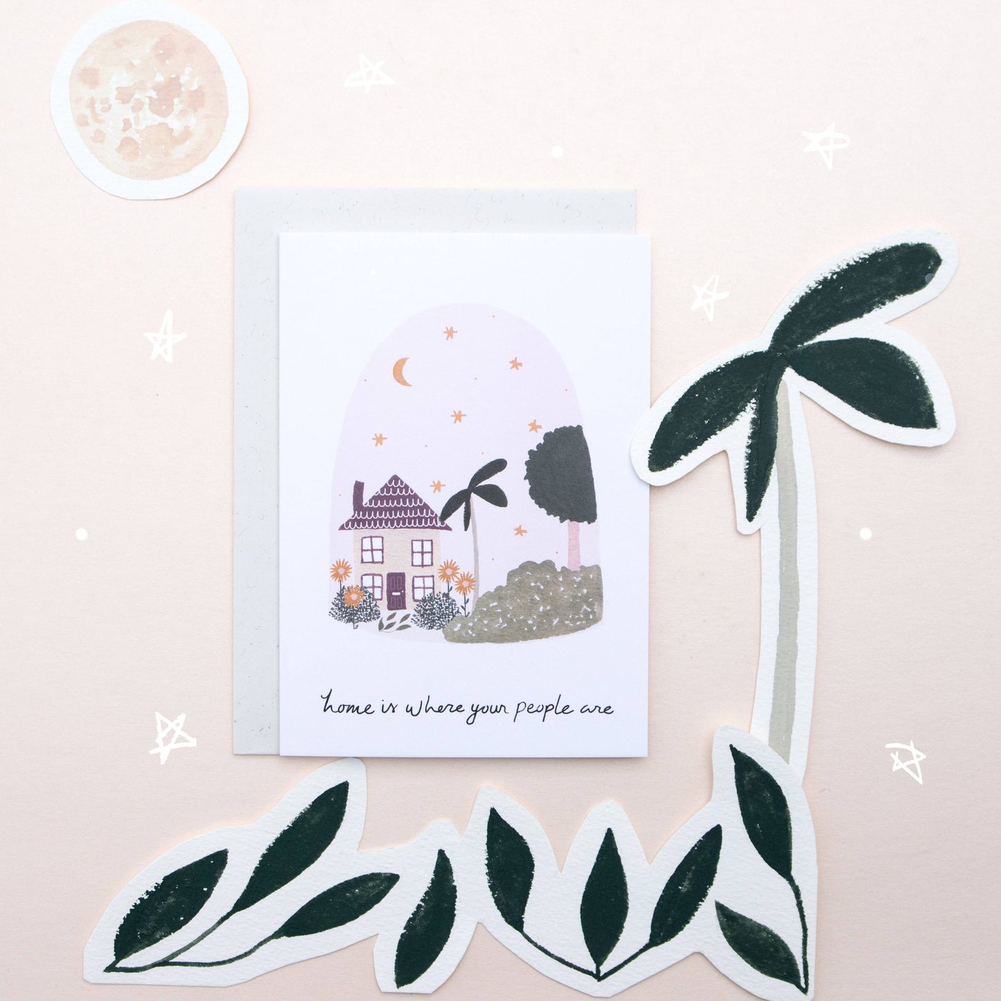 Greeting card with house illustration and decorative stickers on a light pink background