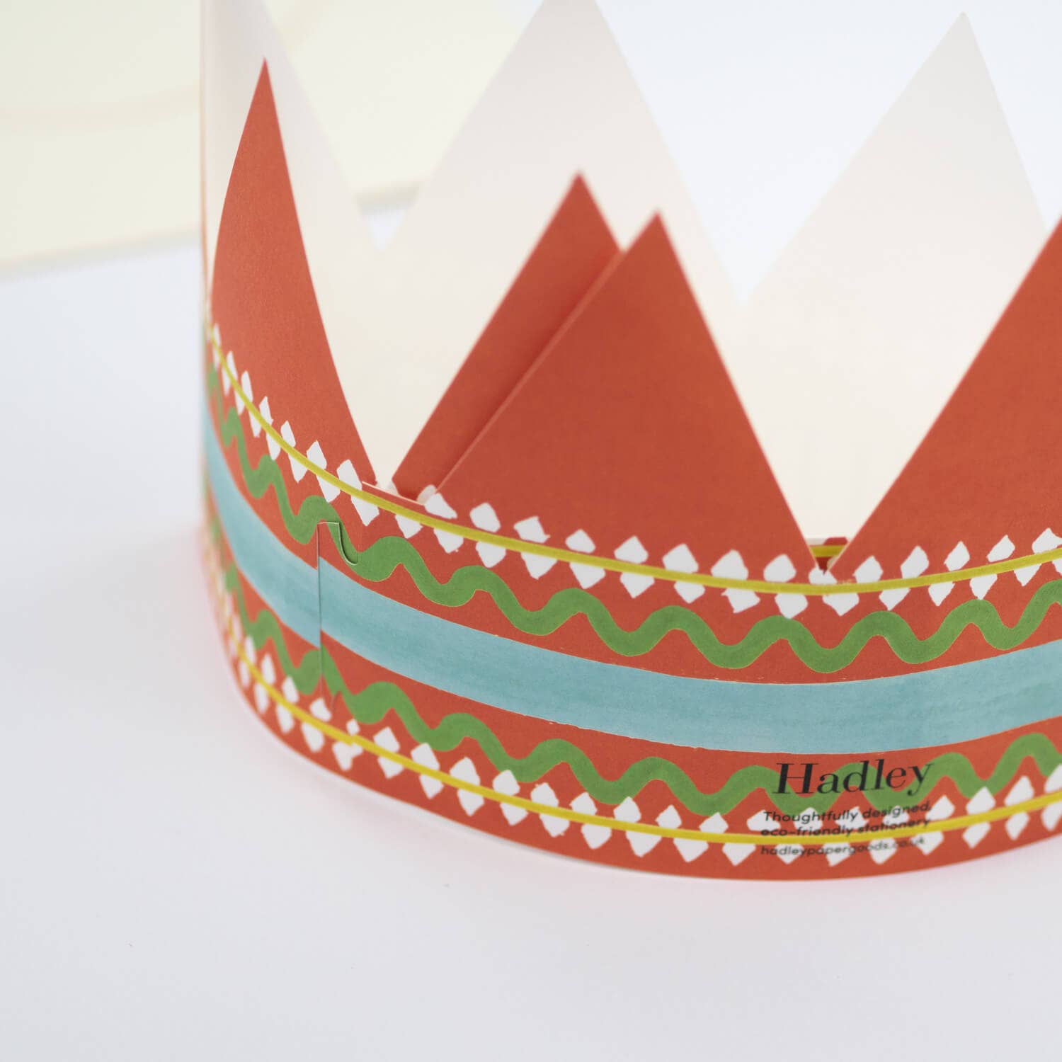 Colorful paper crown with geometric patterns on a white background