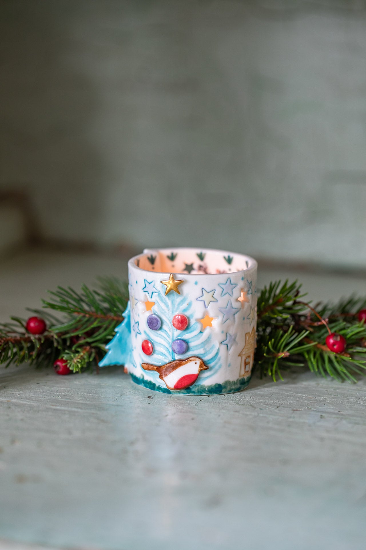 Decorative candle with Christmas design on a neutral background by Katie Almond