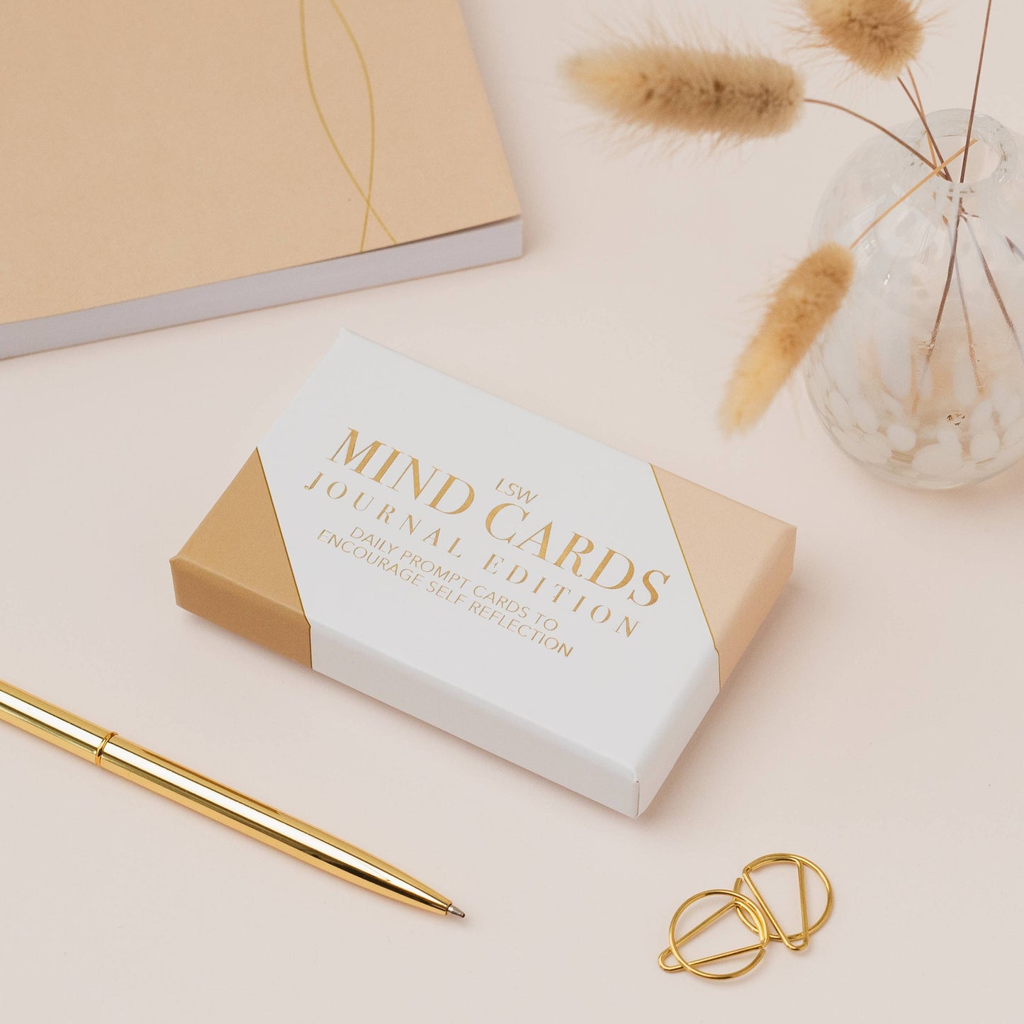 Box of 'Mind Cards Journal Edition' with a gold pen and decorative elements on a light background
