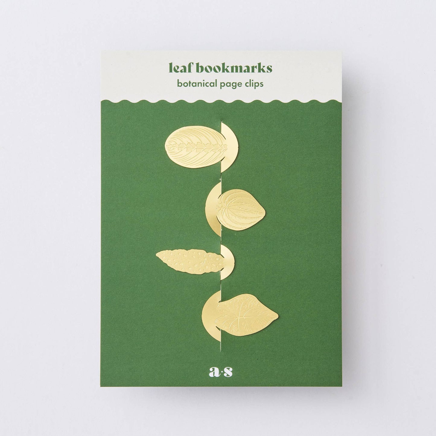 Packaging of a leaf bookmark set with four brass leaf clips on a green background, titled 'Leaf bookmarks botanical page clips' with the brand 'A-S' visible.