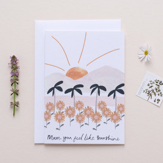 Greeting card with sun and palm tree design on a beige background