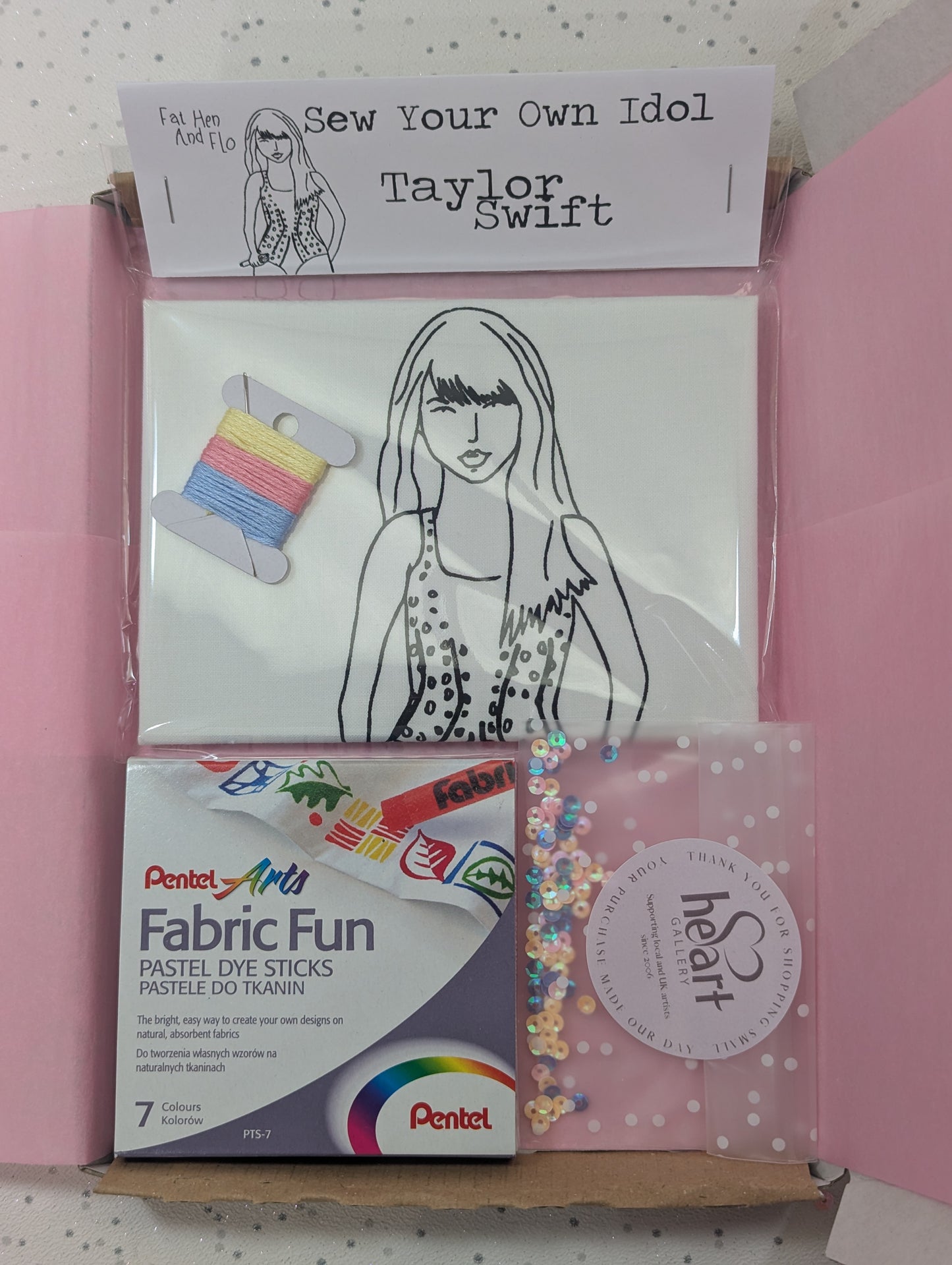 Packaging of 'Sew Your Own Idol Taylor Swift' craft kit with Pentel Fabric Fun dye sticks on a white background and sequins and thread - crafted kits by post