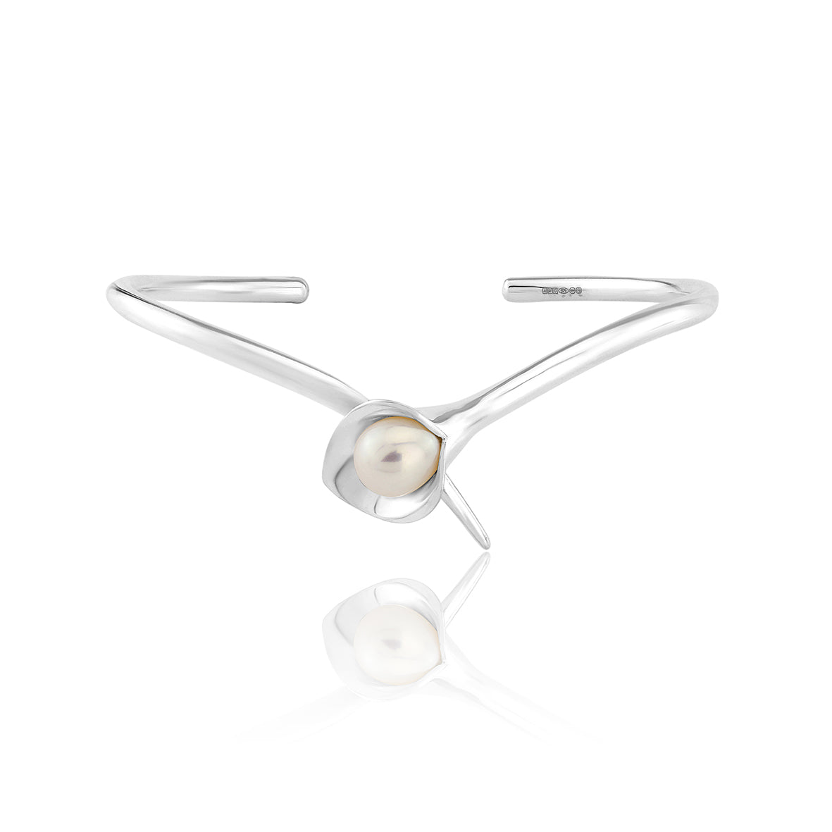 A silver bangle bracelet with a large cultured freshwater pearl, displayed against a white background.Amanda Cox, jewellery handmade in Hebden Bridge Yorkshire for Heart Gallery