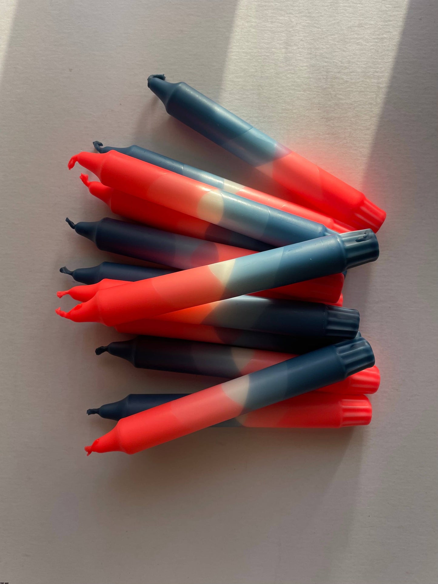 Stack of neon coral and teal blue candles by The Singing Rabbit for Heart Gallery