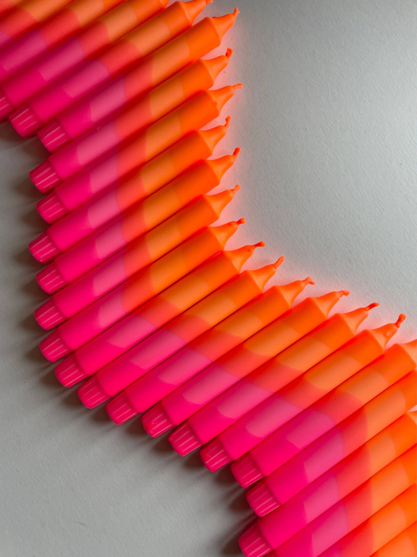 Stack of pink and orange candles by The Singing Rabbit