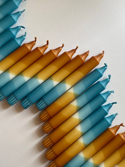 Blue and caramel candles arranged in a pattern on a light background
