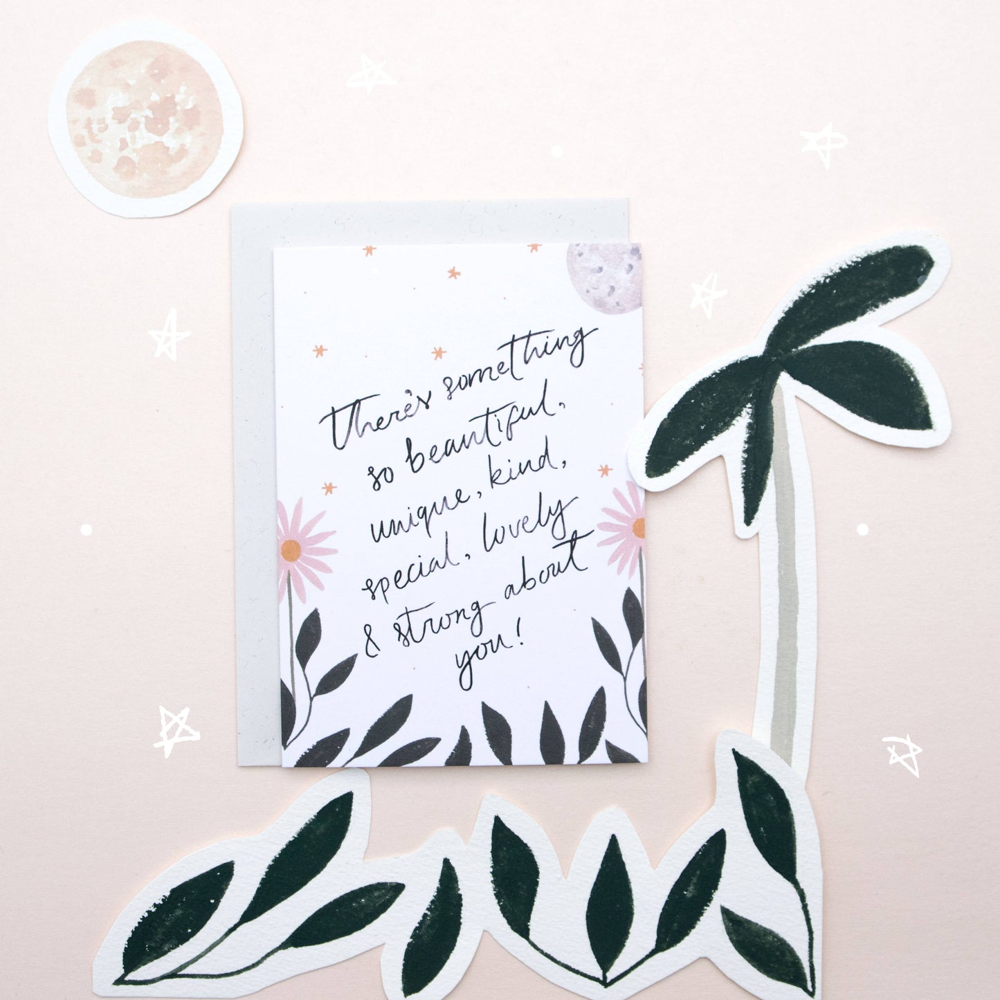 Motivational card with floral design and decorative leaves on a light pink background
