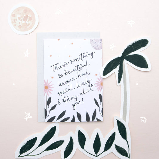 Motivational card with floral design and decorative leaves on a light pink background