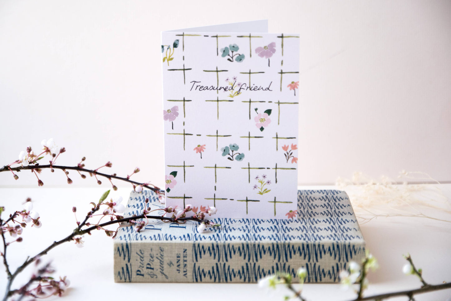 Stack of books with a decorative card on a white background