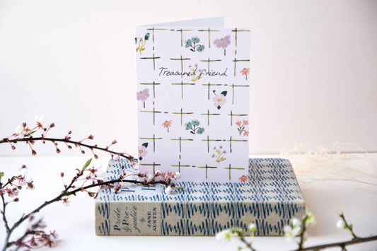 Stack of books with a decorative card on a white background