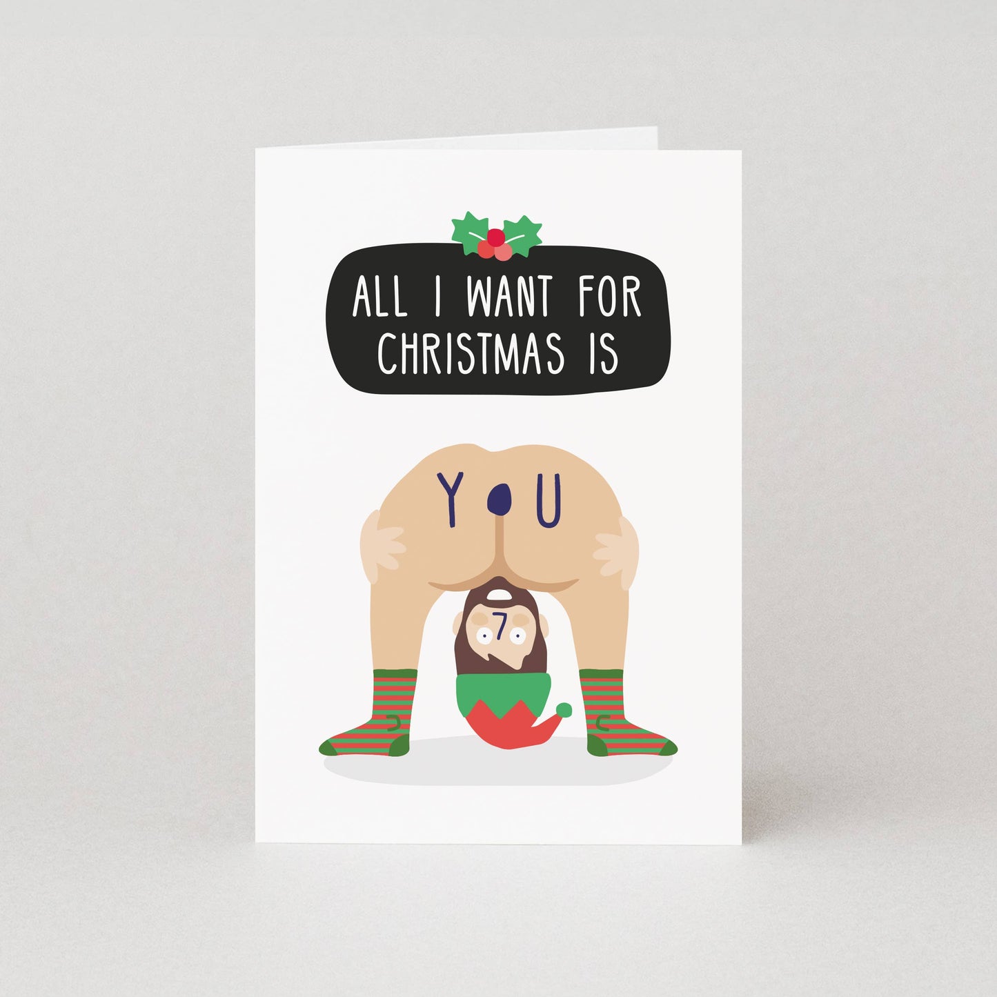 Card with a humorous illustration of a person in a Santa hat and socks, with text 'All I want for Christmas is you'.