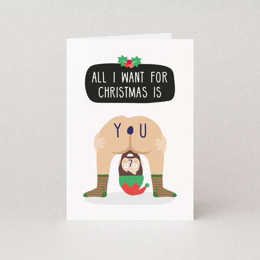 Card with a humorous illustration of a person in a Santa hat and socks, with text 'All I want for Christmas is you'.