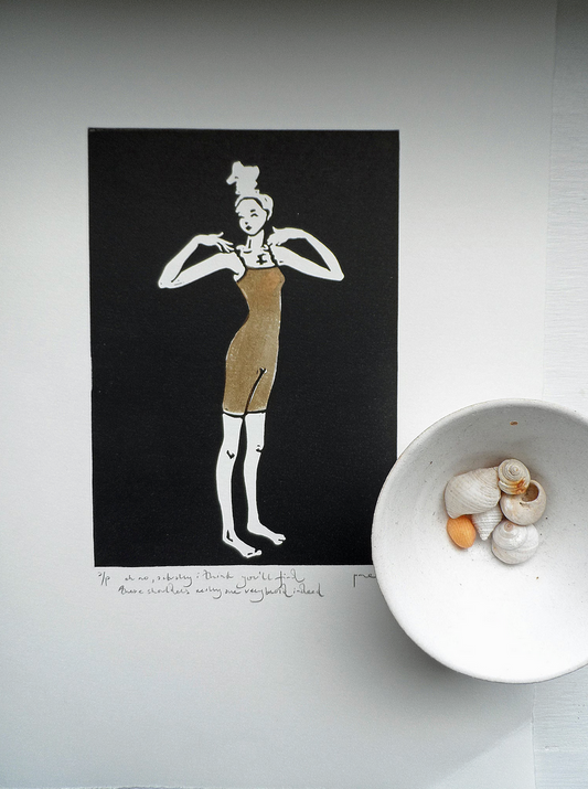 A signed and titled original linocut called Broad Shoulders by Polly Marix-Evans, depicting a figure, displayed on a flat surface with a bowl of shells to the side.