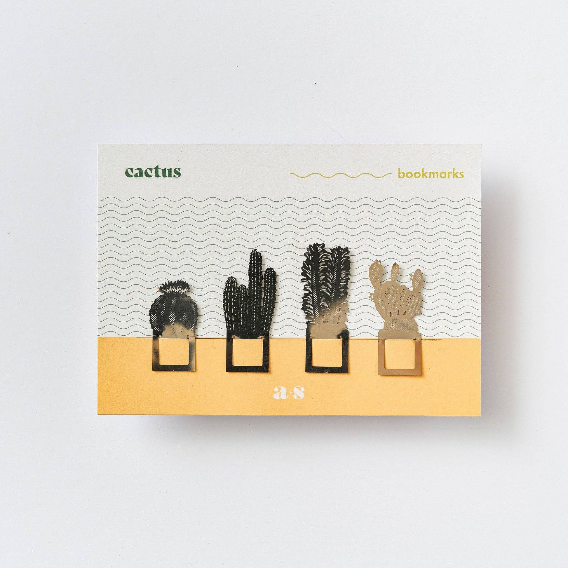 A set of four metal cactus-shaped bookmarks in silver colour, displayed in packaging with a desert-themed design and the brand name 'Another Studio'.