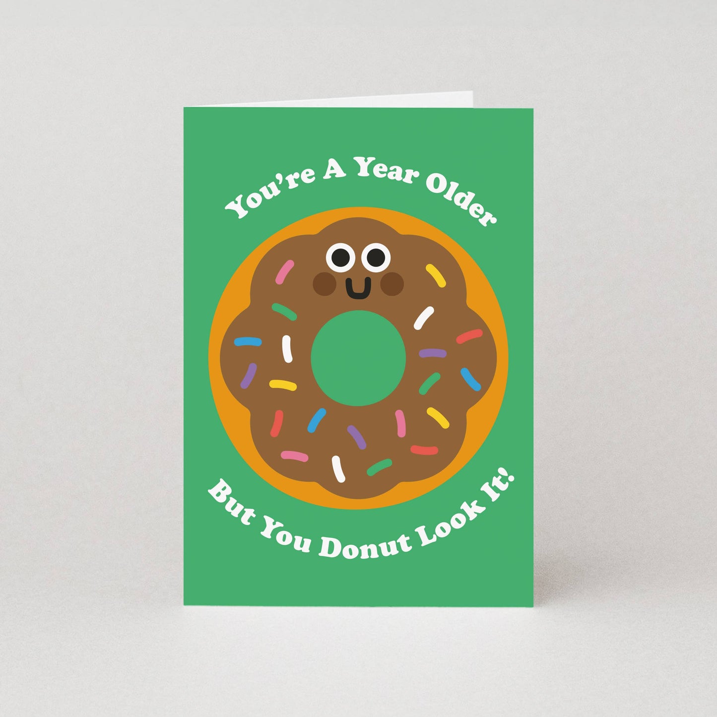 Greeting card with a cartoon donut on a green background