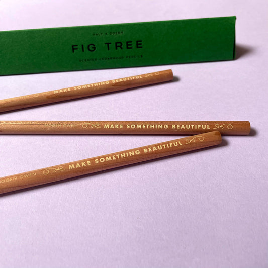 half a dozen scented cedarwood pencils with 'Make Something Beautiful' text on a purple background, accompanied by a letterpress box labeled 'Fig Tree' by Imogen Owen for Heart Gallery