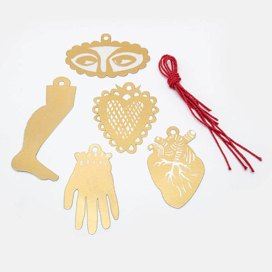 Gold gift tags for wrapping presents featuring  a face, heart, hand, and anatomical heart on a white background with red string.