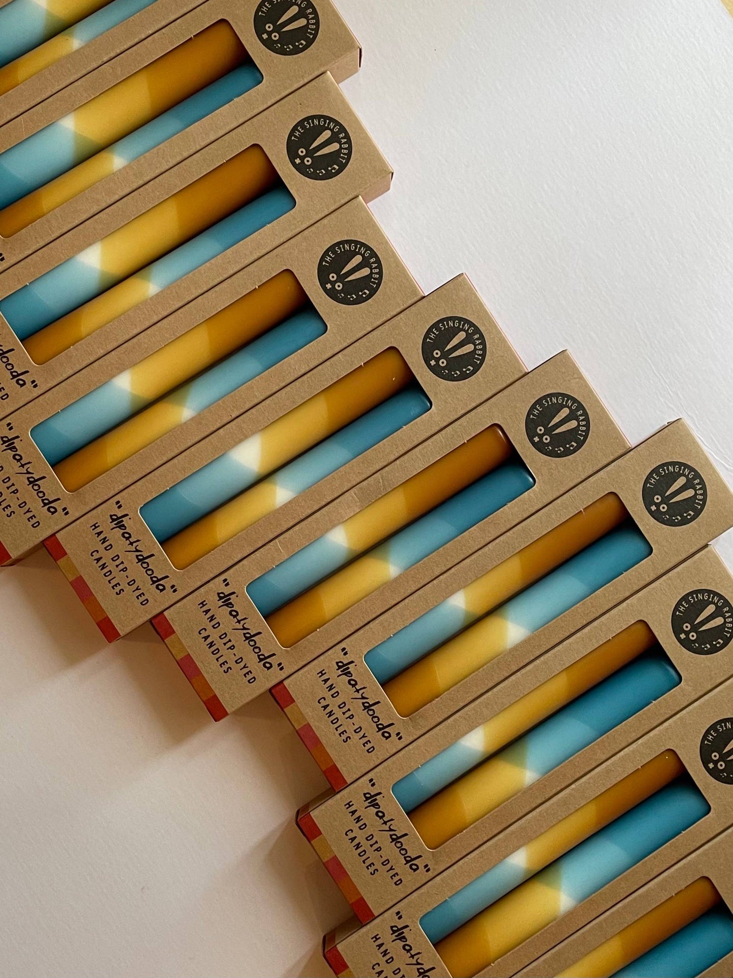 Stack of boxes containing blue and caramel ccandles by the Singing Rabbit