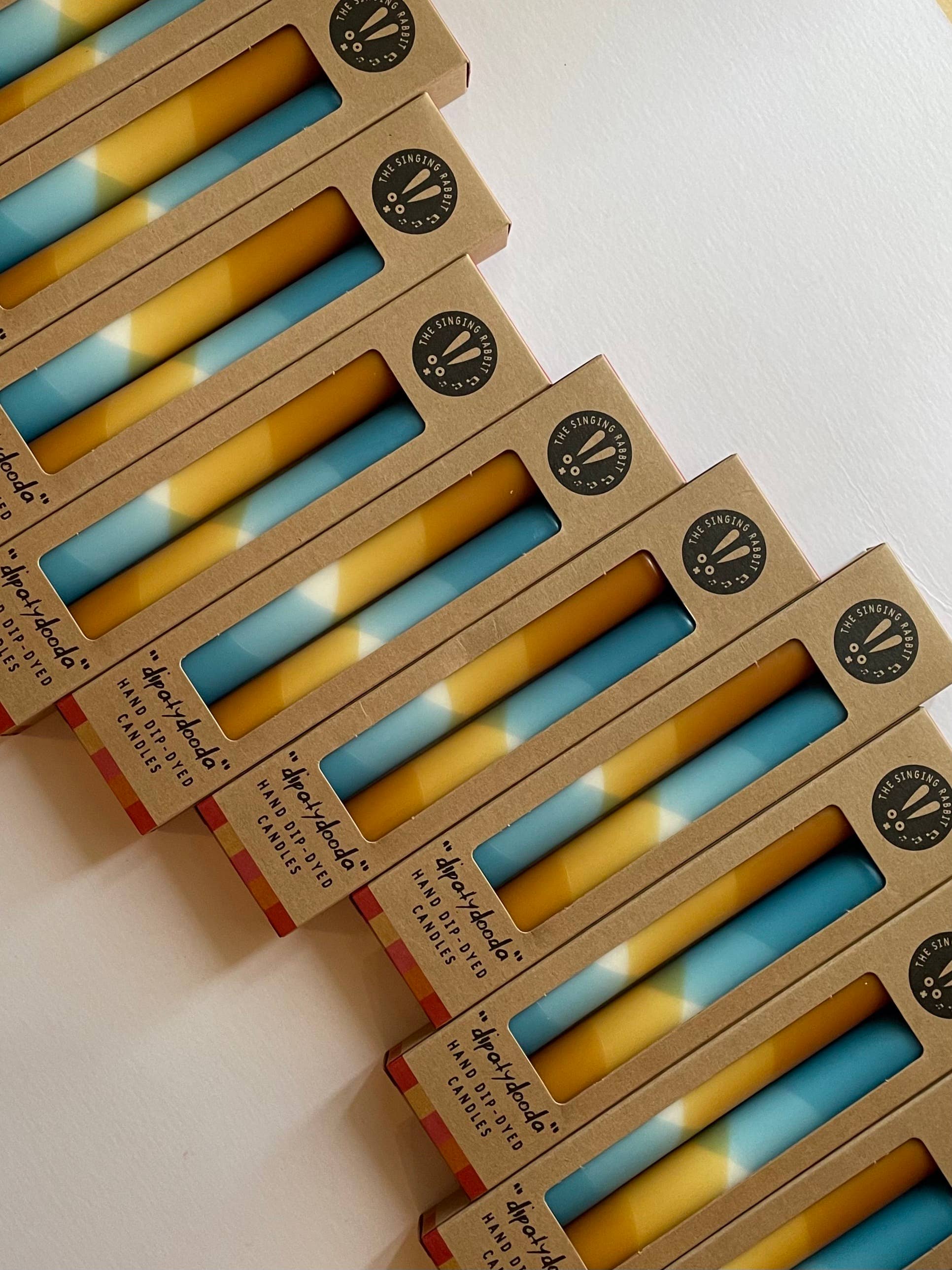 Stack of boxes containing blue and caramel ccandles by the Singing Rabbit