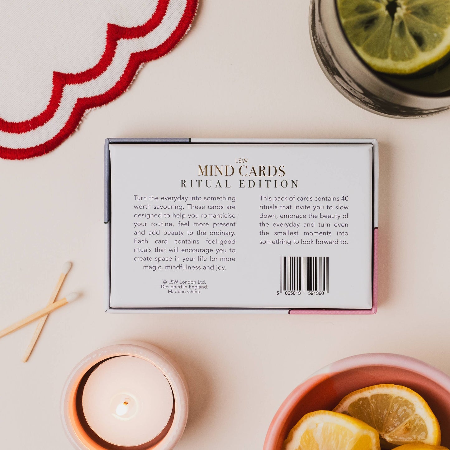 Mind cards packaging with a candle, lemons, and matches on a table
