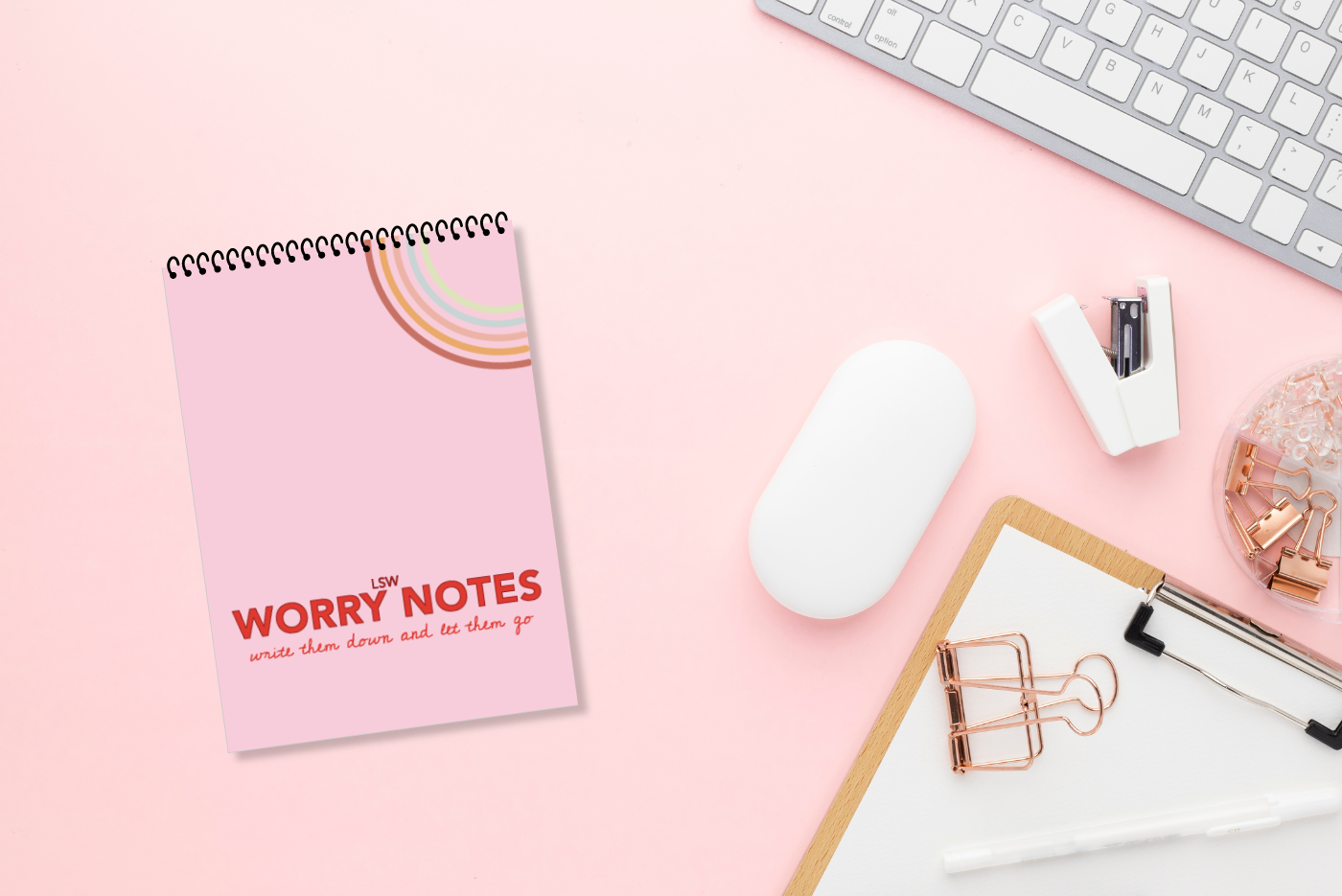 A white lined paper, wire-bound notebook with a pink cover featuring the title 'Worry Notes' in red text, along with a small decorative element on the top  right by LSW for Heart Gallery