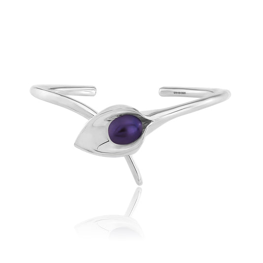 A silver bangle bracelet with a large cultured freshwater pearl, displayed against a white background.Amanda Cox, jewellery handmade in Hebden Bridge Yorkshire for Heart Gallery