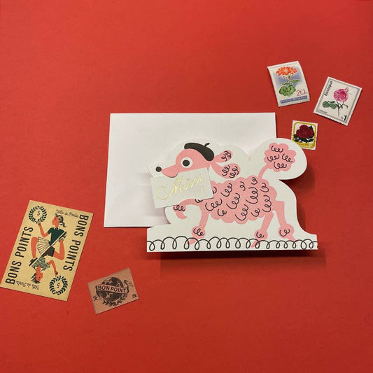 Card with a pink poodle carrying a Merci sign in its mouth on a red background
