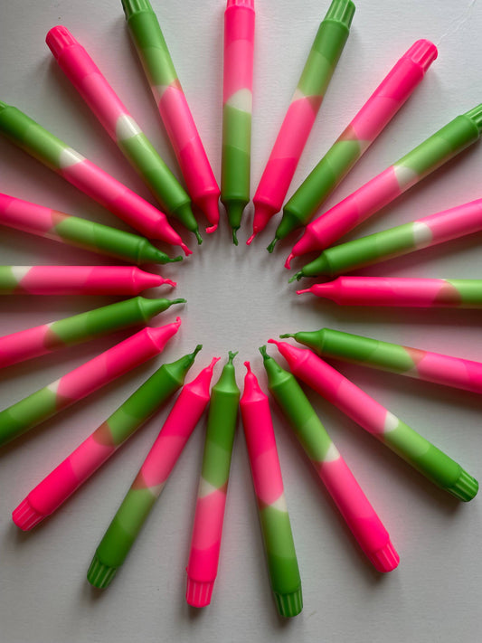 Neon Pink and green hand dip dyed candles by The Singing Rabbit for Heart Gallery arranged in a circular pattern on a white background