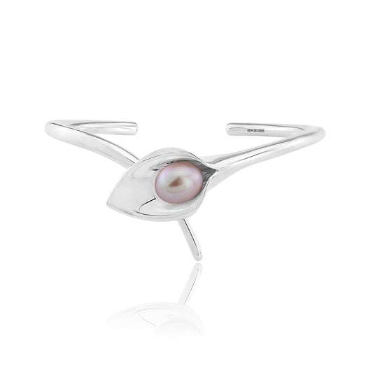 A silver bangle bracelet with a large cultured freshwater pearl, displayed against a white background.Amanda Cox, jewellery handmade in Hebden Bridge Yorkshire for Heart Gallery