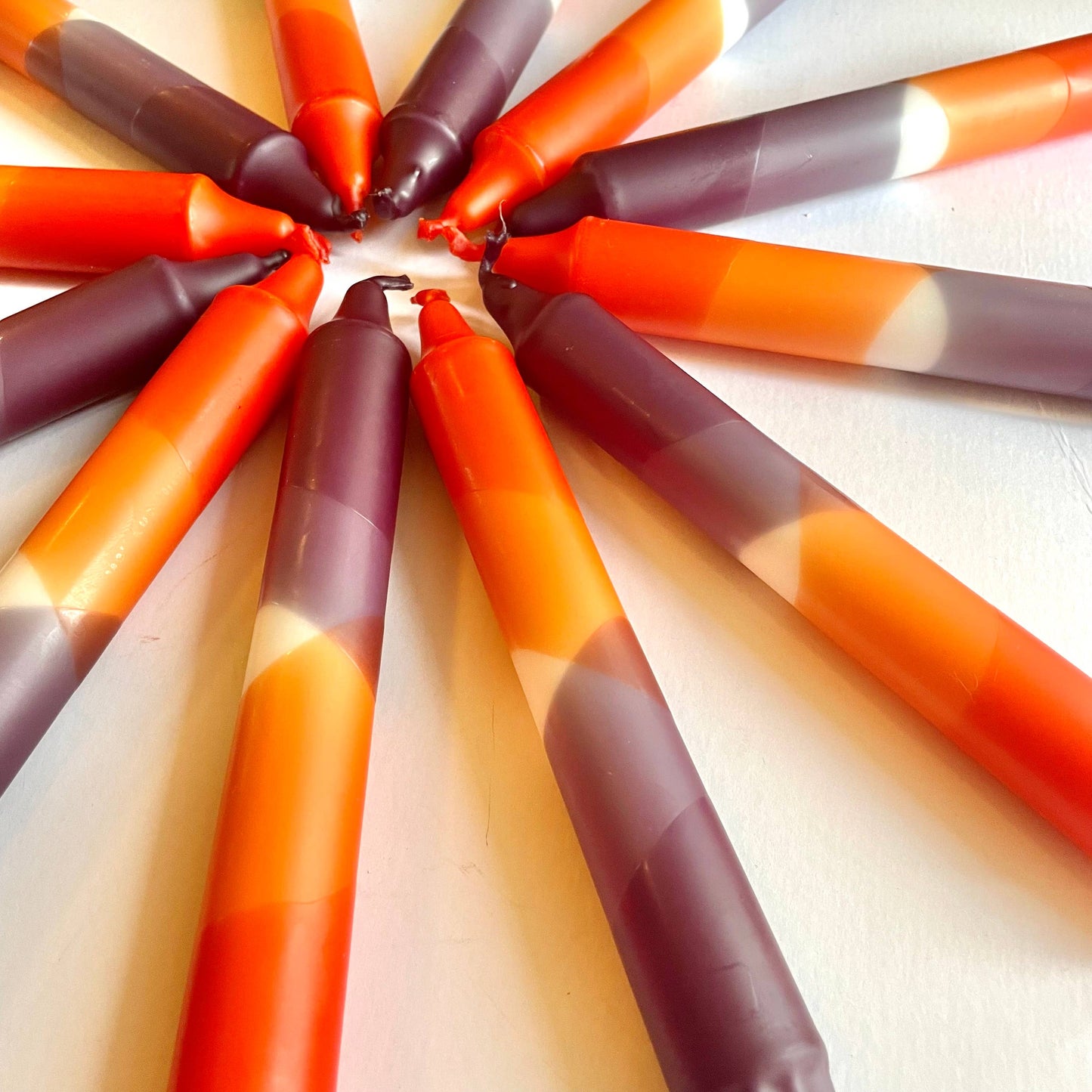 Stack of aubergine and rust red candles by The Singing Rabbit for Heart Gallery