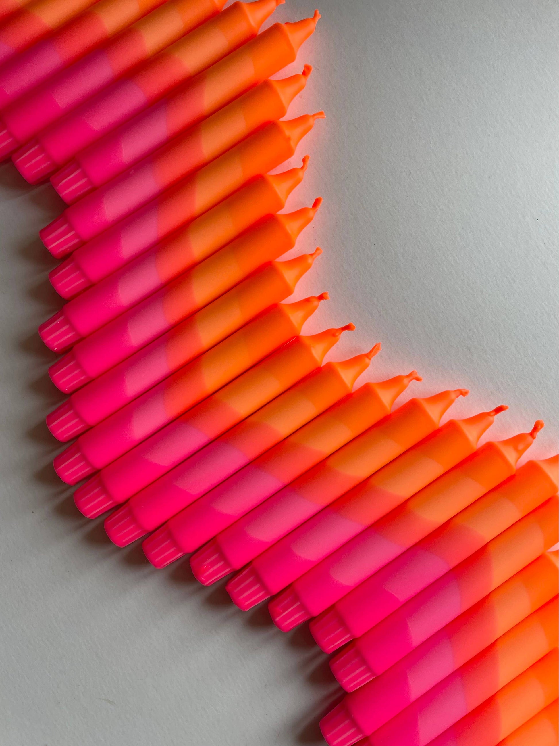 Stack of pink and orange candles by The Singing Rabbit