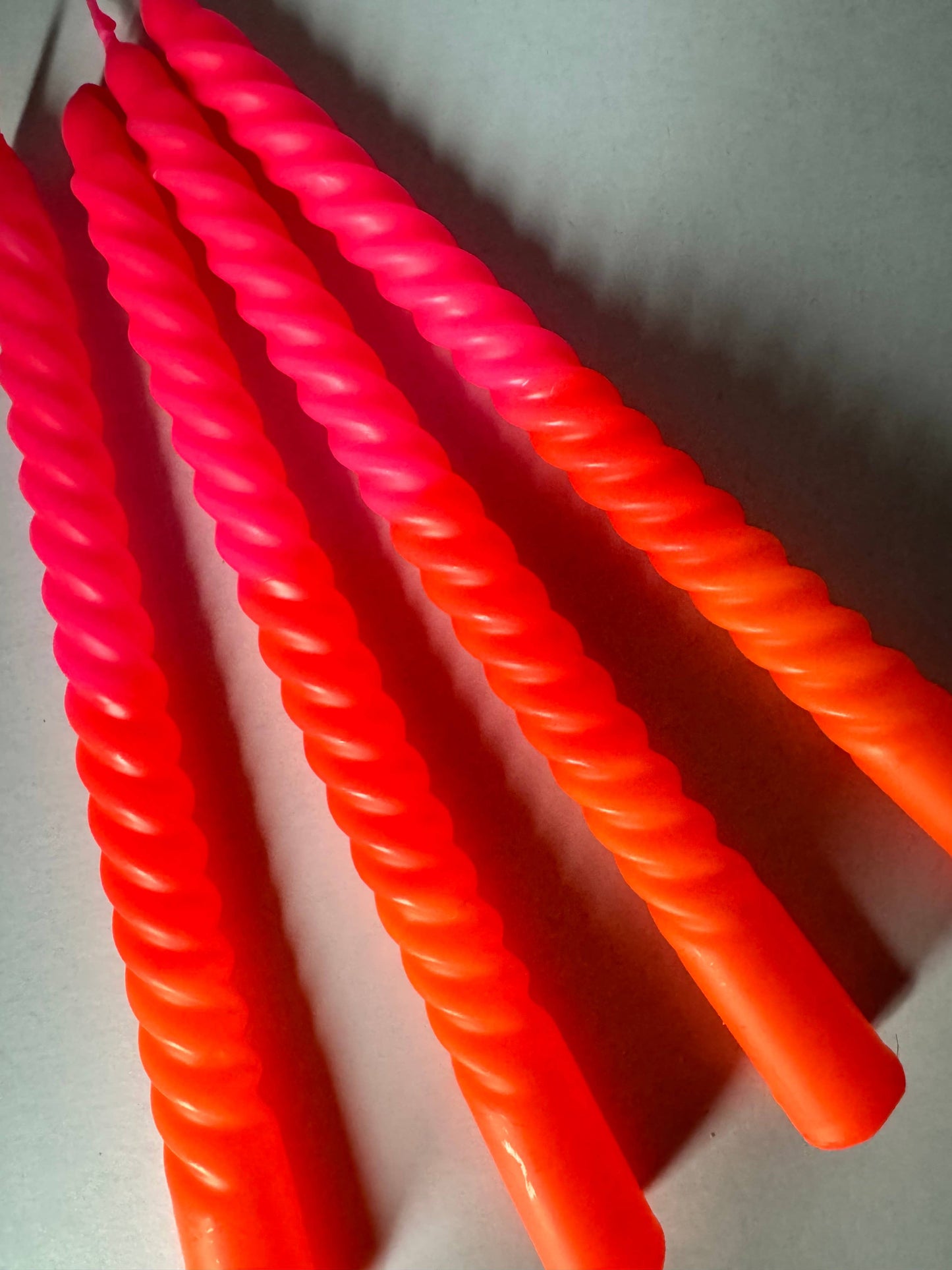 Close-up of orange and pink twisted straws on a white background